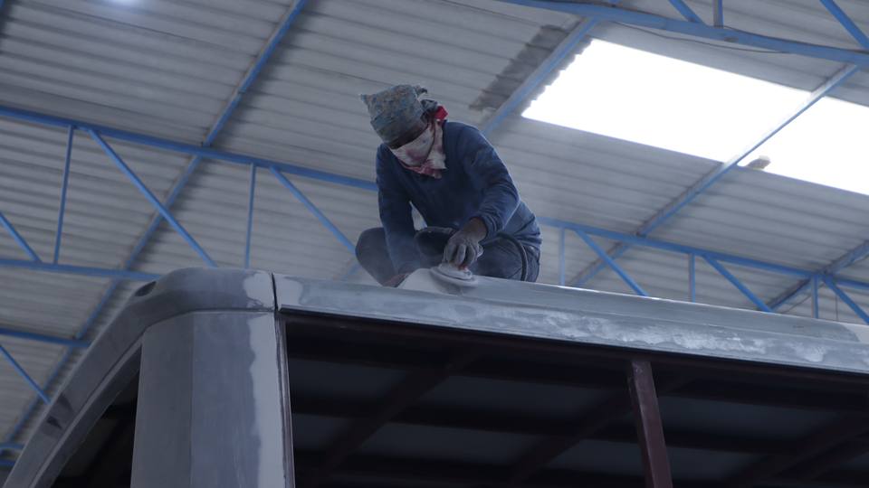 Worker finishing the roof of a bus body at Gobind Coach