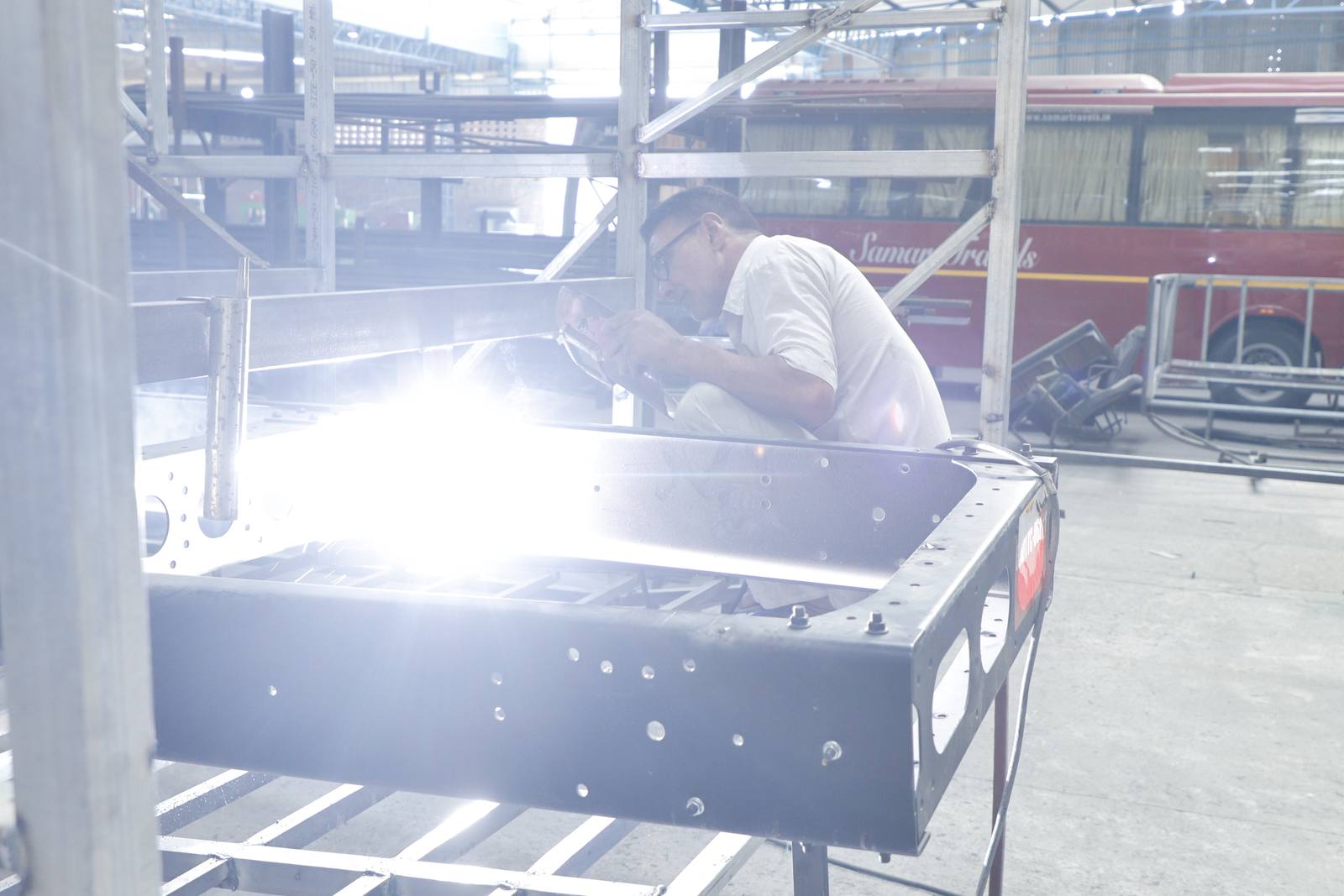 Welder working on a bus body frame at the Gobind Coach plant