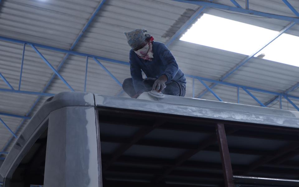 Gobind Coach worker finishing the roof panel of a bus body